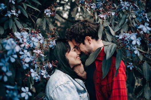 Happy couple sharing a romantic moment surrounded by beautiful blue flowers.